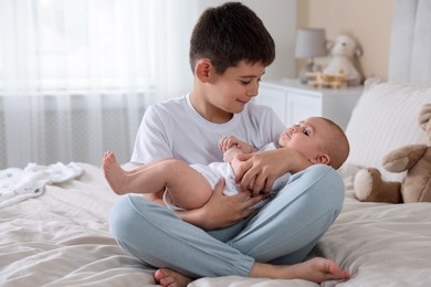 Photo of Cute little brothers on bed at home