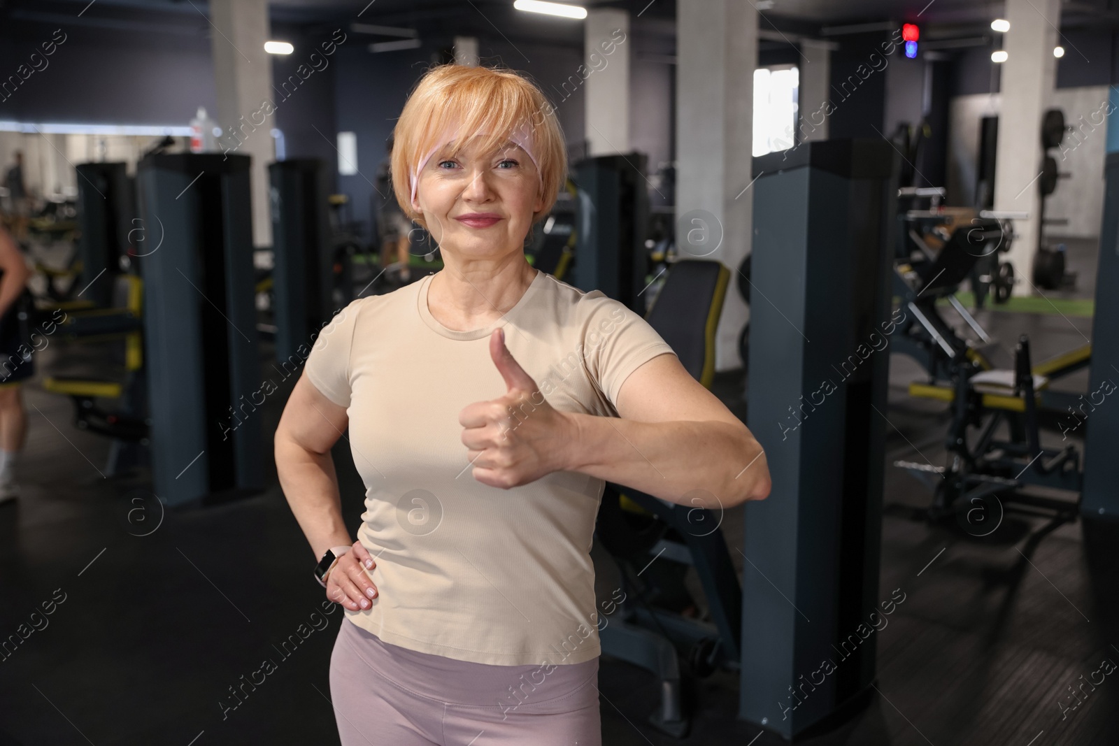 Senior woman showing thumbs up in gym Photo of Senior woman showing thumbs up in gym