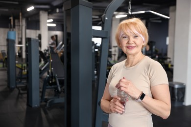 Photo of Senior woman with bottle of water in gym