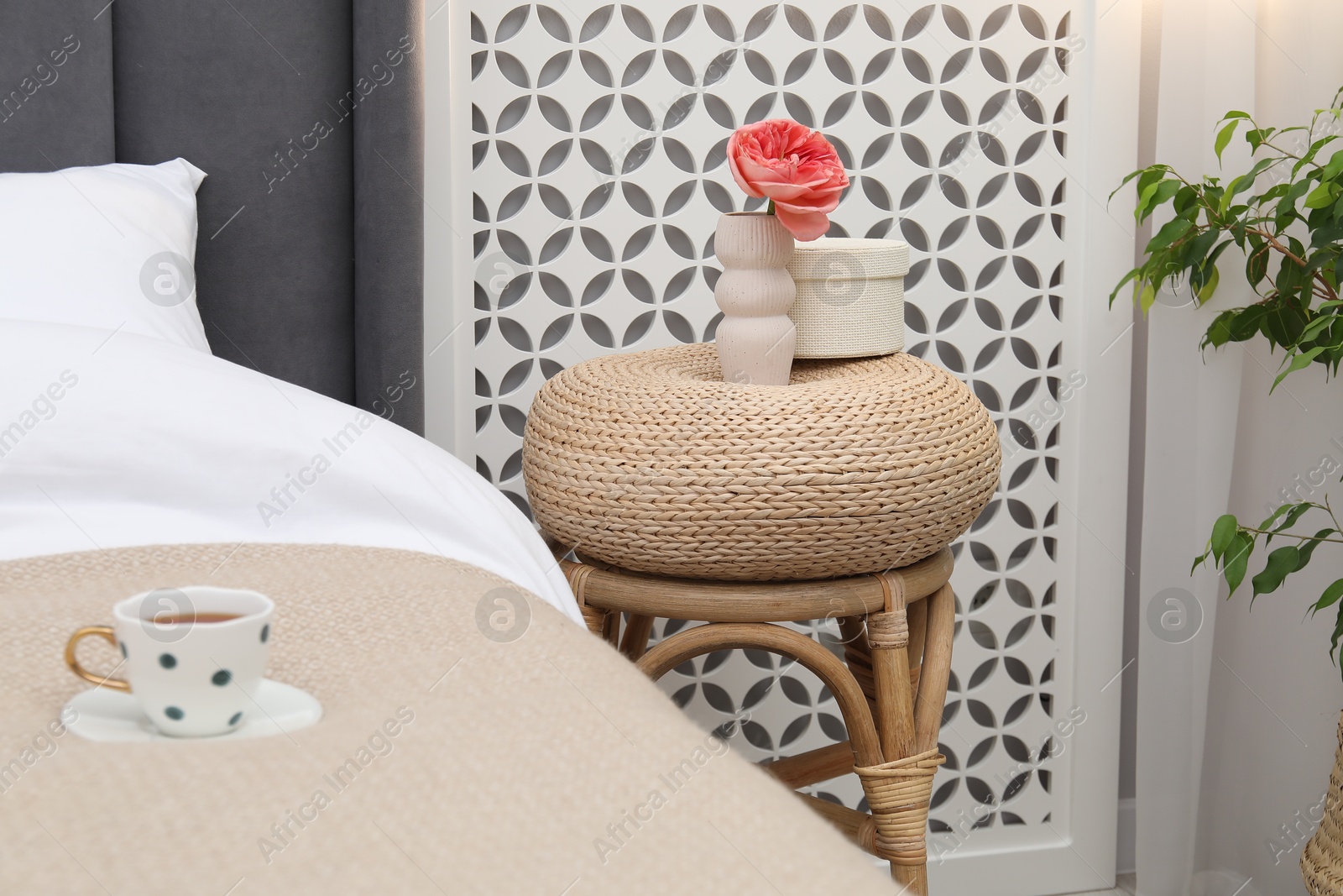 Side table with decor near bed indoors Photo of Side table with decor near bed indoors