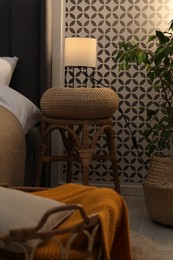 Photo of Side table with lamp near bed indoors
