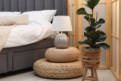 Photo of Side table with lamp near bed indoors