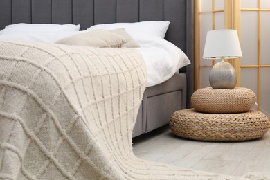 Photo of Side table with lamp near bed indoors