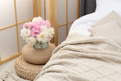 Photo of Side table with flowers near bed indoors