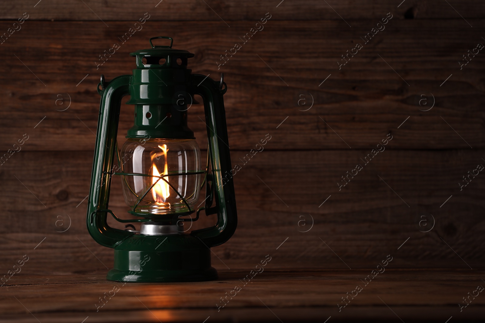 Photo of One vintage kerosene lantern on wooden table, space for text