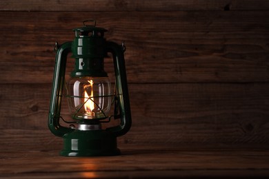 Photo of One vintage kerosene lantern on wooden table, space for text