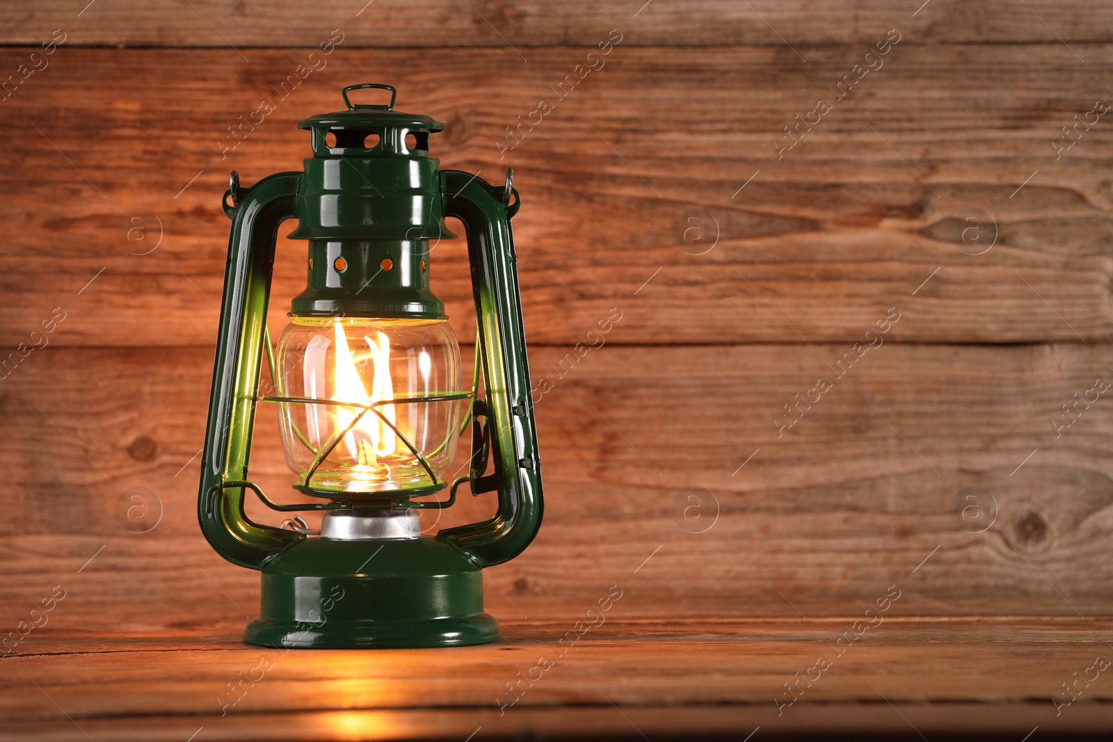 One vintage kerosene lantern on wooden table, space for text Photo of One vintage kerosene lantern on wooden table, space for text