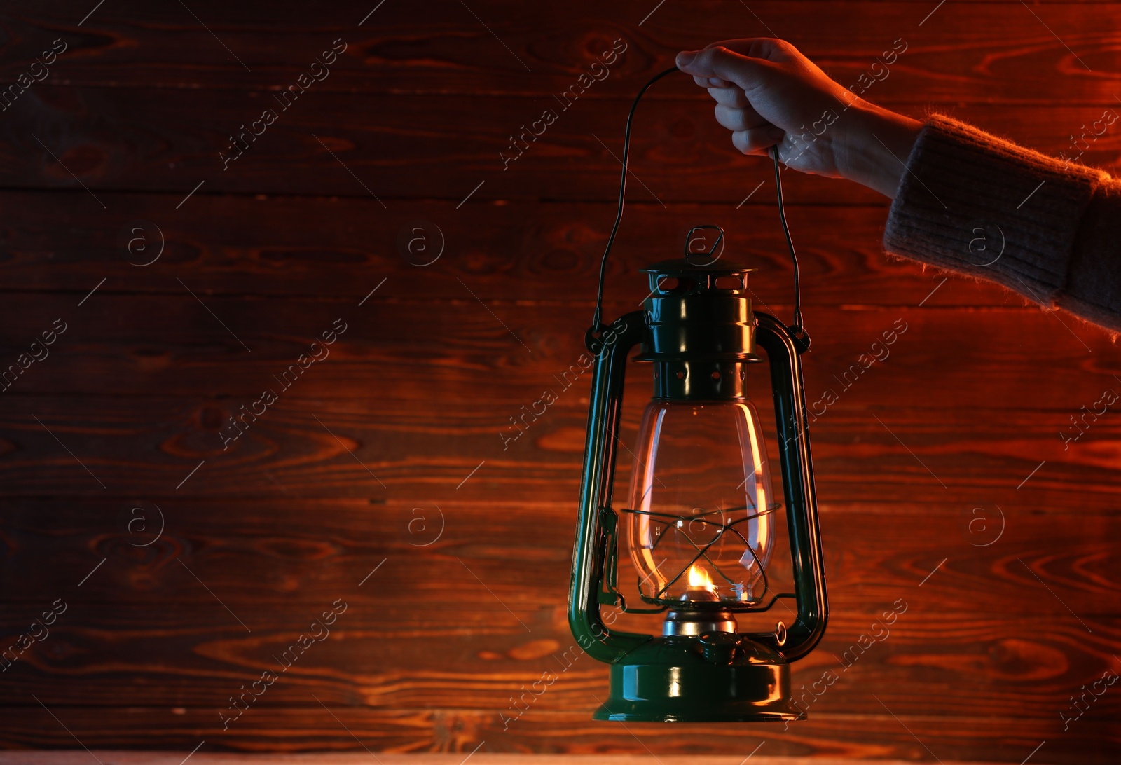 Woman holding vintage kerosene lantern near wooden wall, closeup. Space for text Photo of Woman holding vintage kerosene lantern near wooden wall, closeup. Space for text