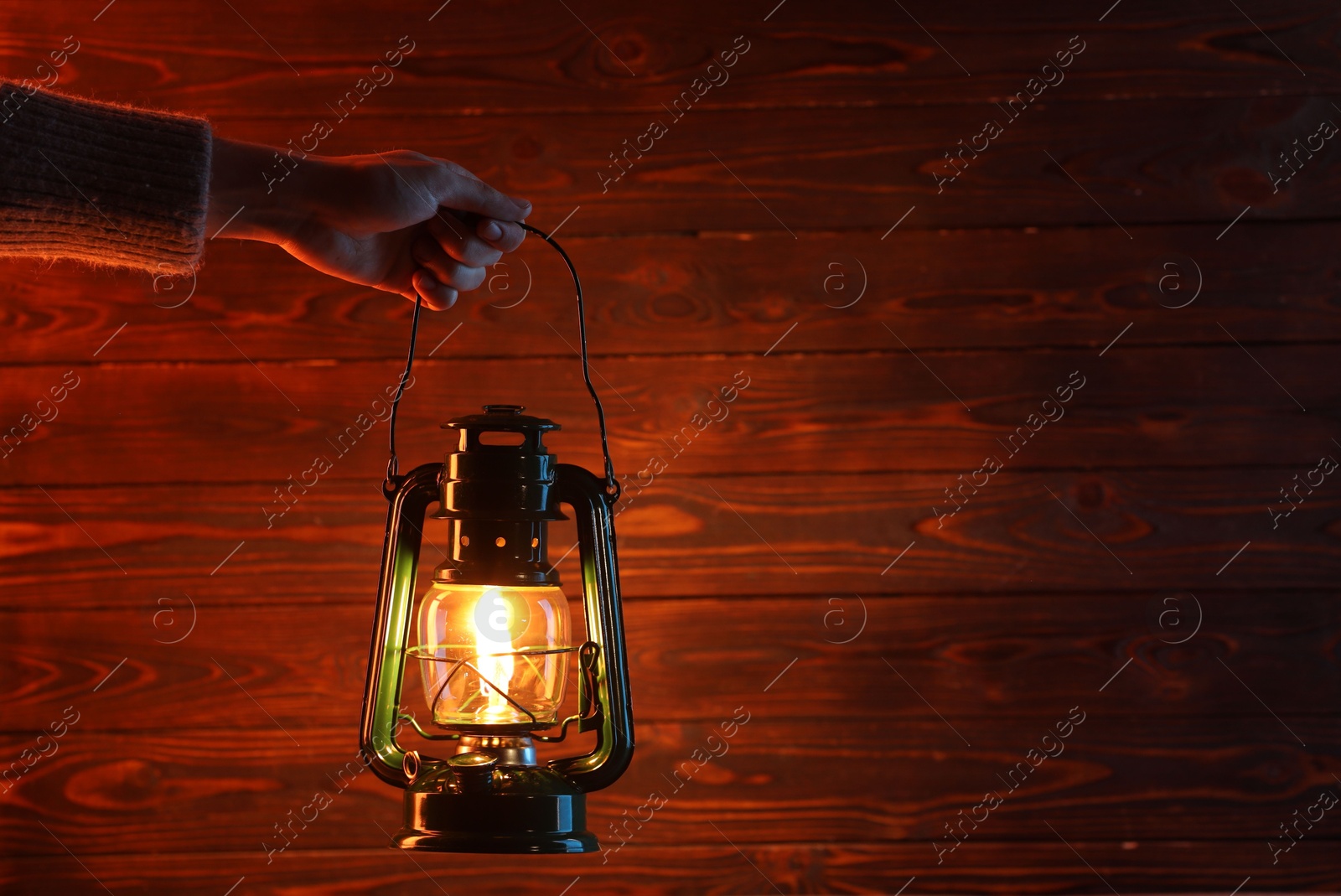 Woman holding vintage kerosene lantern near wooden wall, closeup. Space for text Photo of Woman holding vintage kerosene lantern near wooden wall, closeup. Space for text