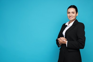 Photo of Confident business woman in suit on light blue background. Space for text