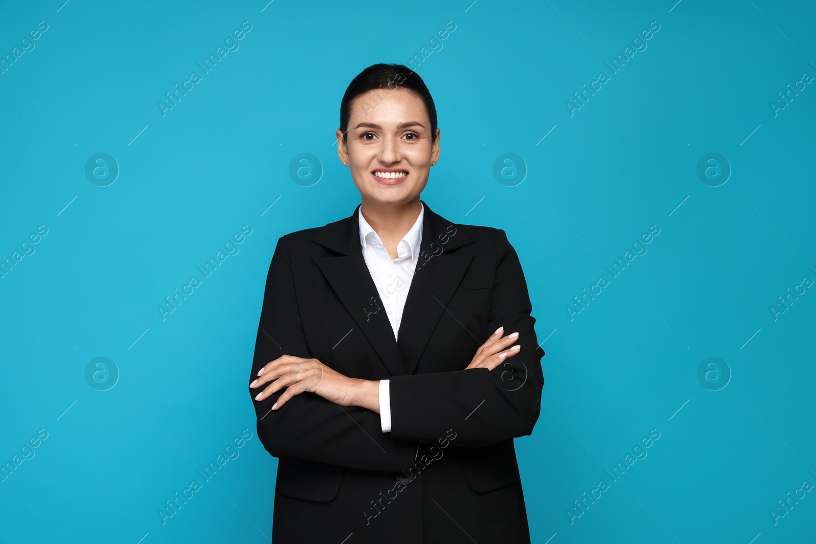 Confident business woman in suit on light blue background Photo of Confident business woman in suit on light blue background