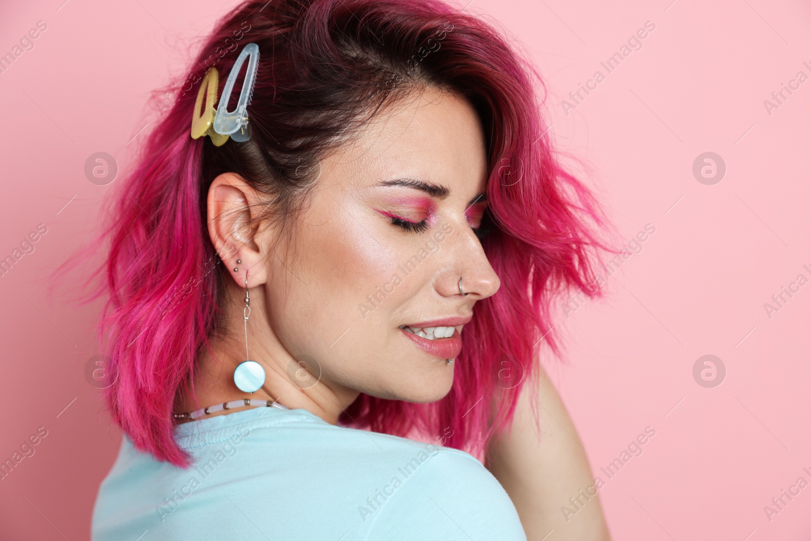 Photo of Beautiful woman with bright dyed hair on pink background