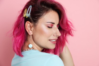 Photo of Beautiful woman with bright dyed hair on pink background