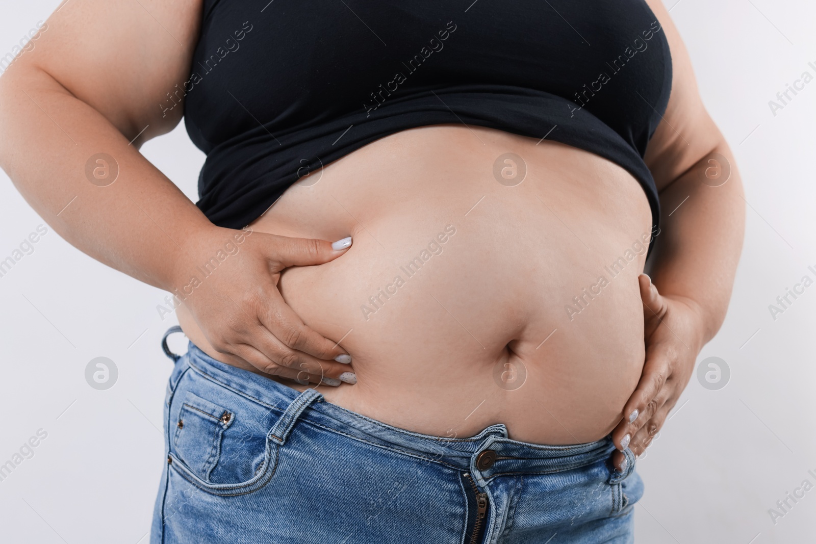 Woman with excessive belly fat on white background, closeup Photo of Woman with excessive belly fat on white background, closeup