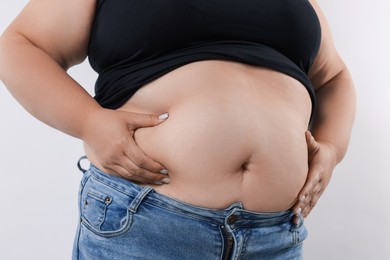 Photo of Woman with excessive belly fat on white background, closeup