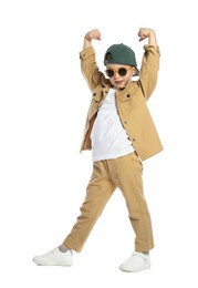 Photo of Cute little boy in sunglasses and baseball hat dancing on white background