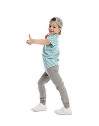Photo of Happy little boy in baseball hat dancing on white background