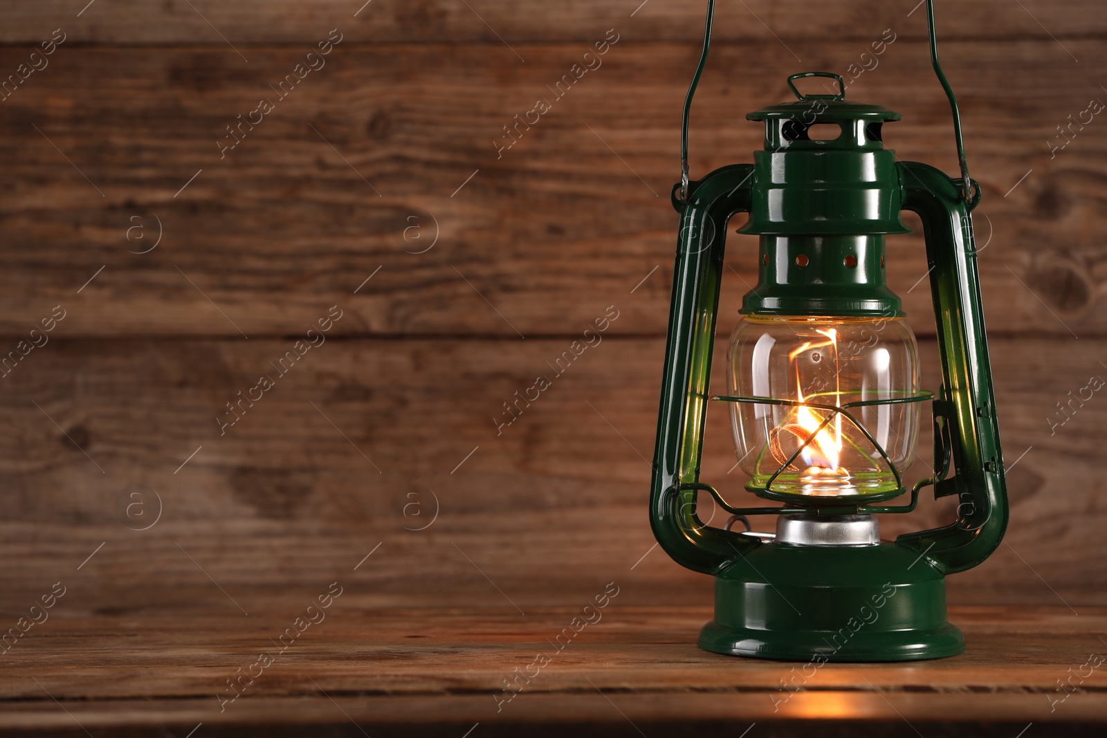 Photo of One vintage kerosene lantern on wooden table, space for text
