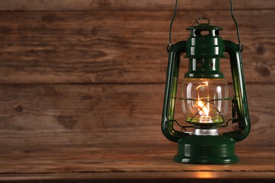 Photo of One vintage kerosene lantern on wooden table, space for text