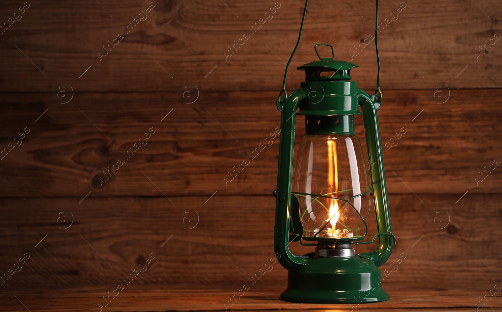 One vintage kerosene lantern on wooden table, space for text Photo of One vintage kerosene lantern on wooden table, space for text