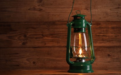 Photo of One vintage kerosene lantern on wooden table, space for text