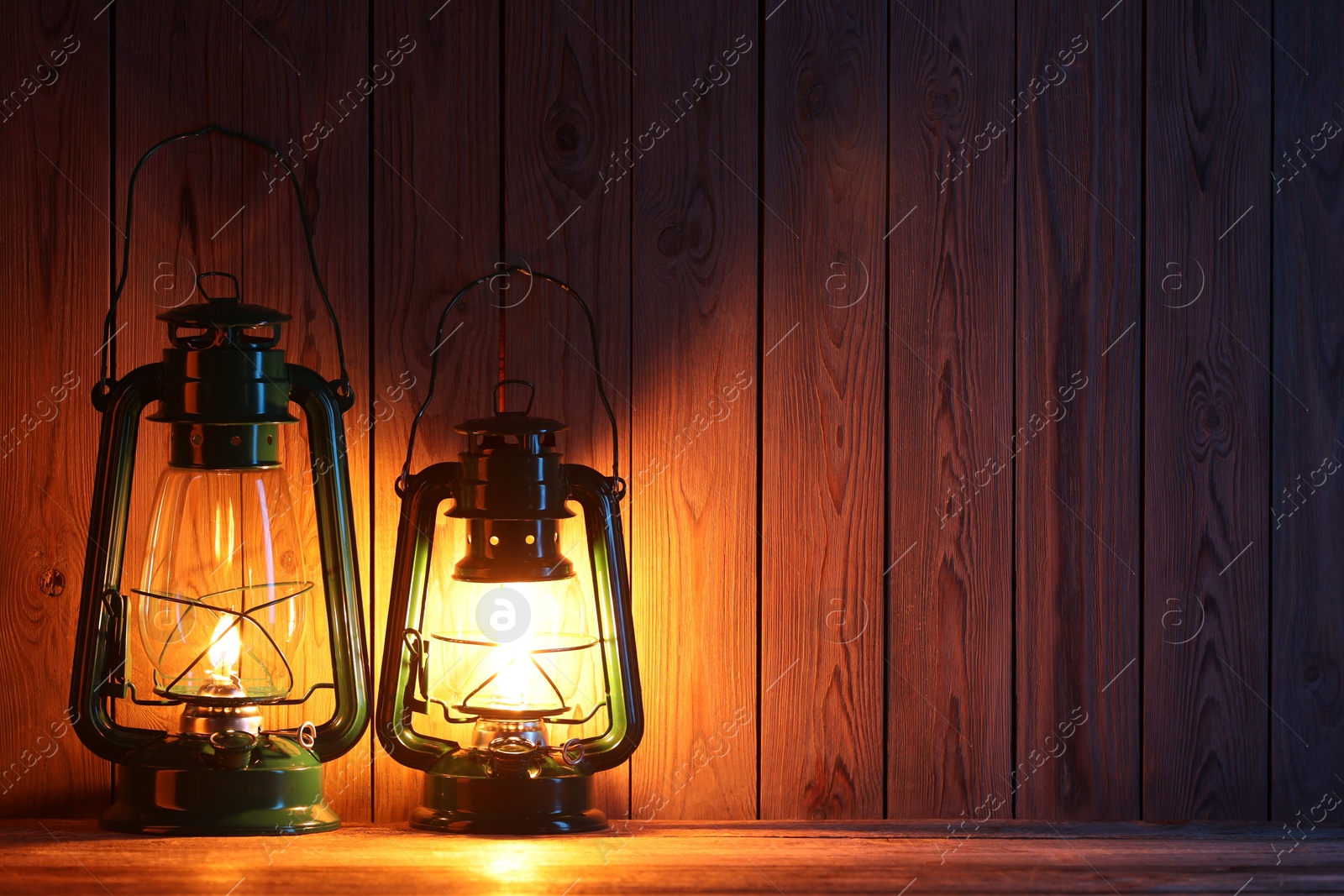 Vintage kerosene lanterns on wooden table, space for text Photo of Vintage kerosene lanterns on wooden table, space for text
