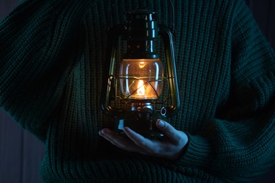 Photo of Woman holding vintage kerosene lantern, closeup view