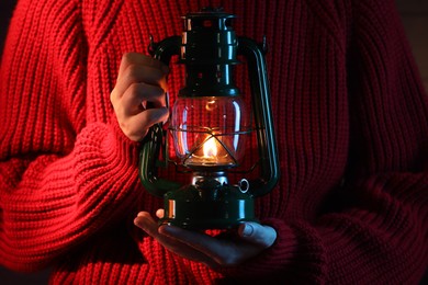 Photo of Woman holding vintage kerosene lantern, closeup view
