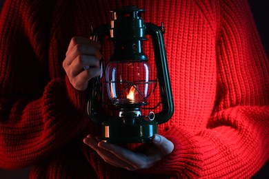 Photo of Woman holding vintage kerosene lantern, closeup view