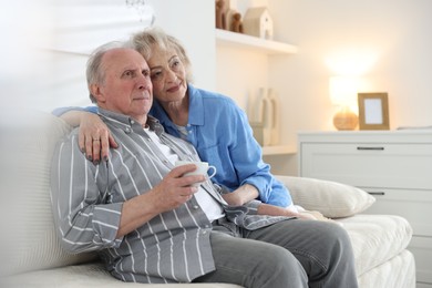 Photo of Lovely senior couple relaxing together on sofa at home