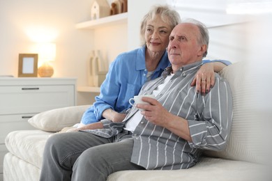 Photo of Lovely senior couple relaxing together on sofa at home