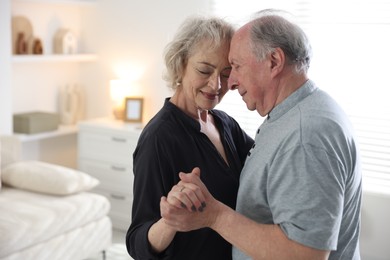Photo of Lovely senior couple at home, space for text