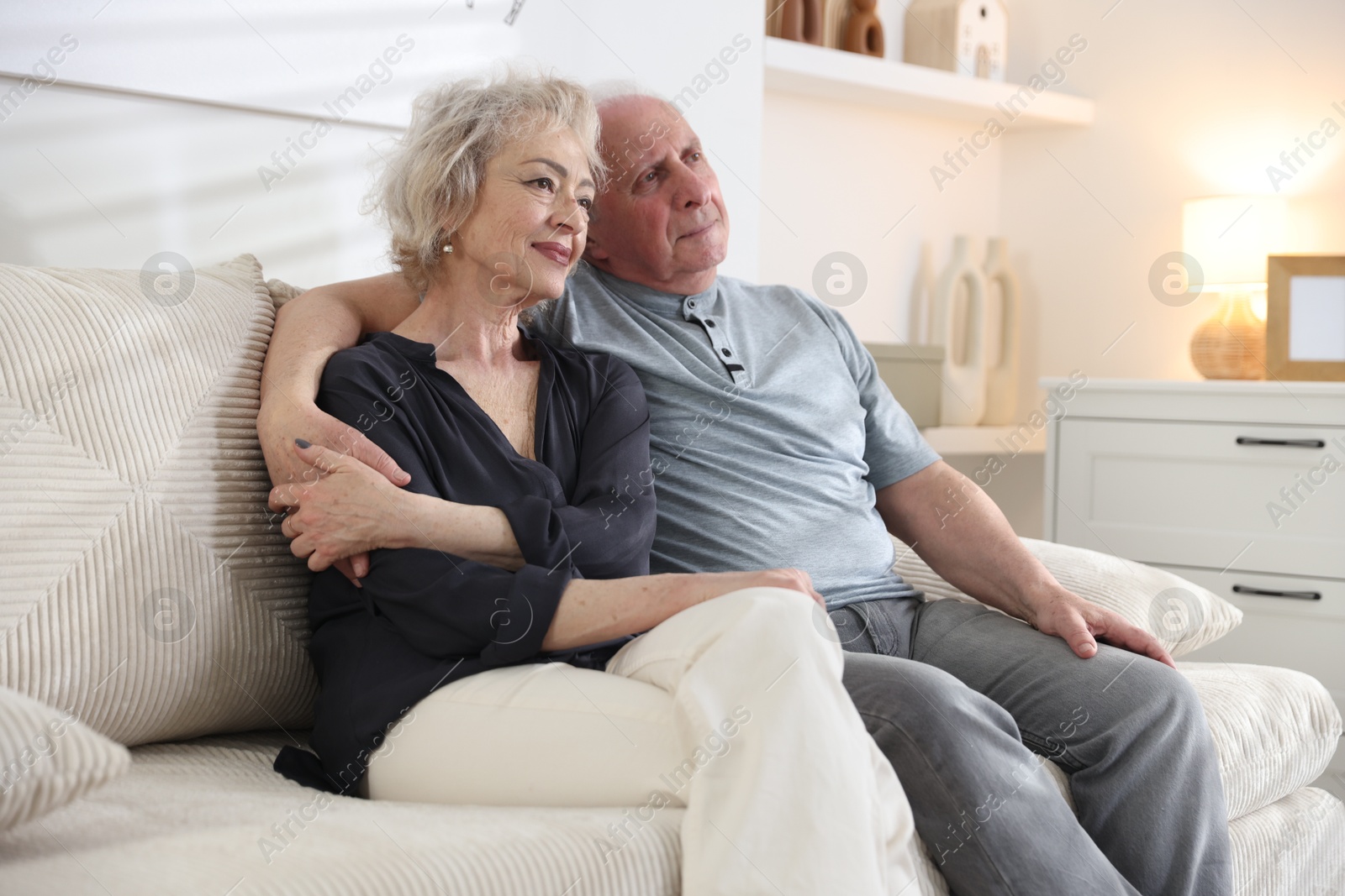 Lovely senior couple relaxing together on sofa at home Photo of Lovely senior couple relaxing together on sofa at home