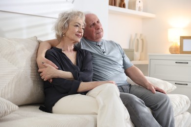 Photo of Lovely senior couple relaxing together on sofa at home