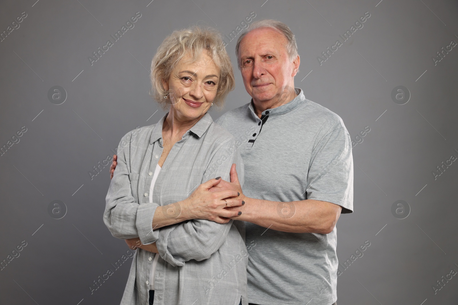 Portrait of lovely senior couple on grey background Photo of Portrait of lovely senior couple on grey background
