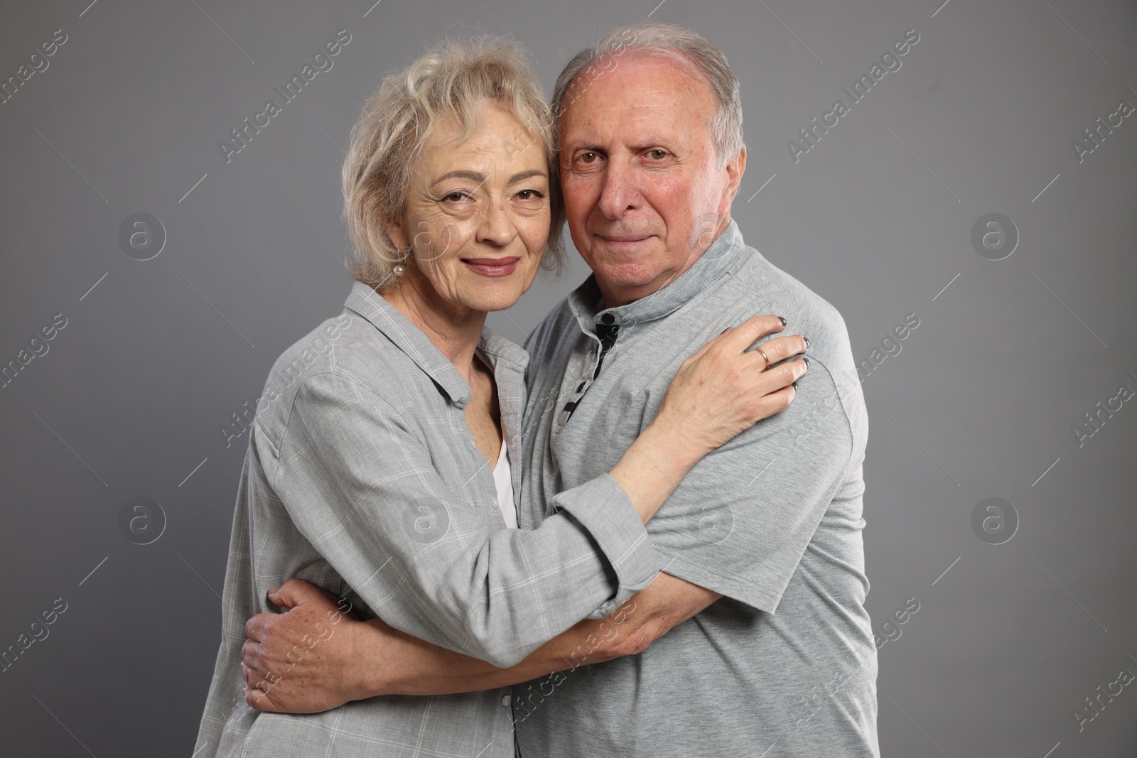 Portrait of lovely senior couple on grey background Photo of Portrait of lovely senior couple on grey background