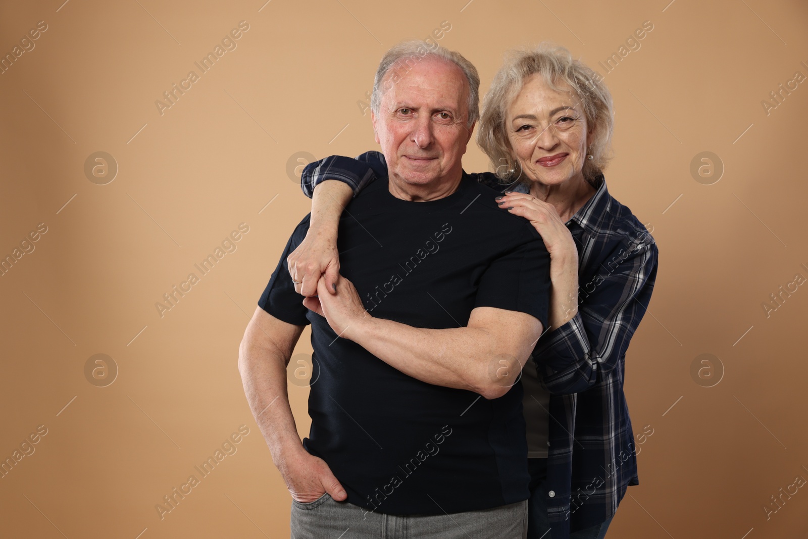 Portrait of lovely senior couple on beige background, space for text Photo of Portrait of lovely senior couple on beige background, space for text