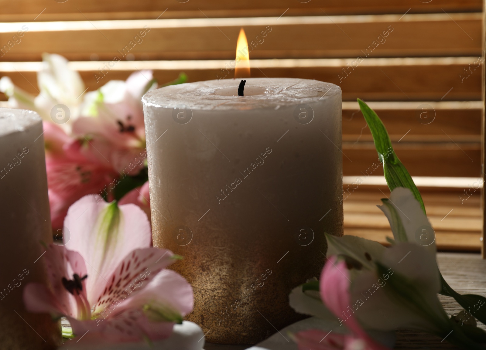 Burning candles and lily flowers on table, closeup Photo of Burning candles and lily flowers on table, closeup
