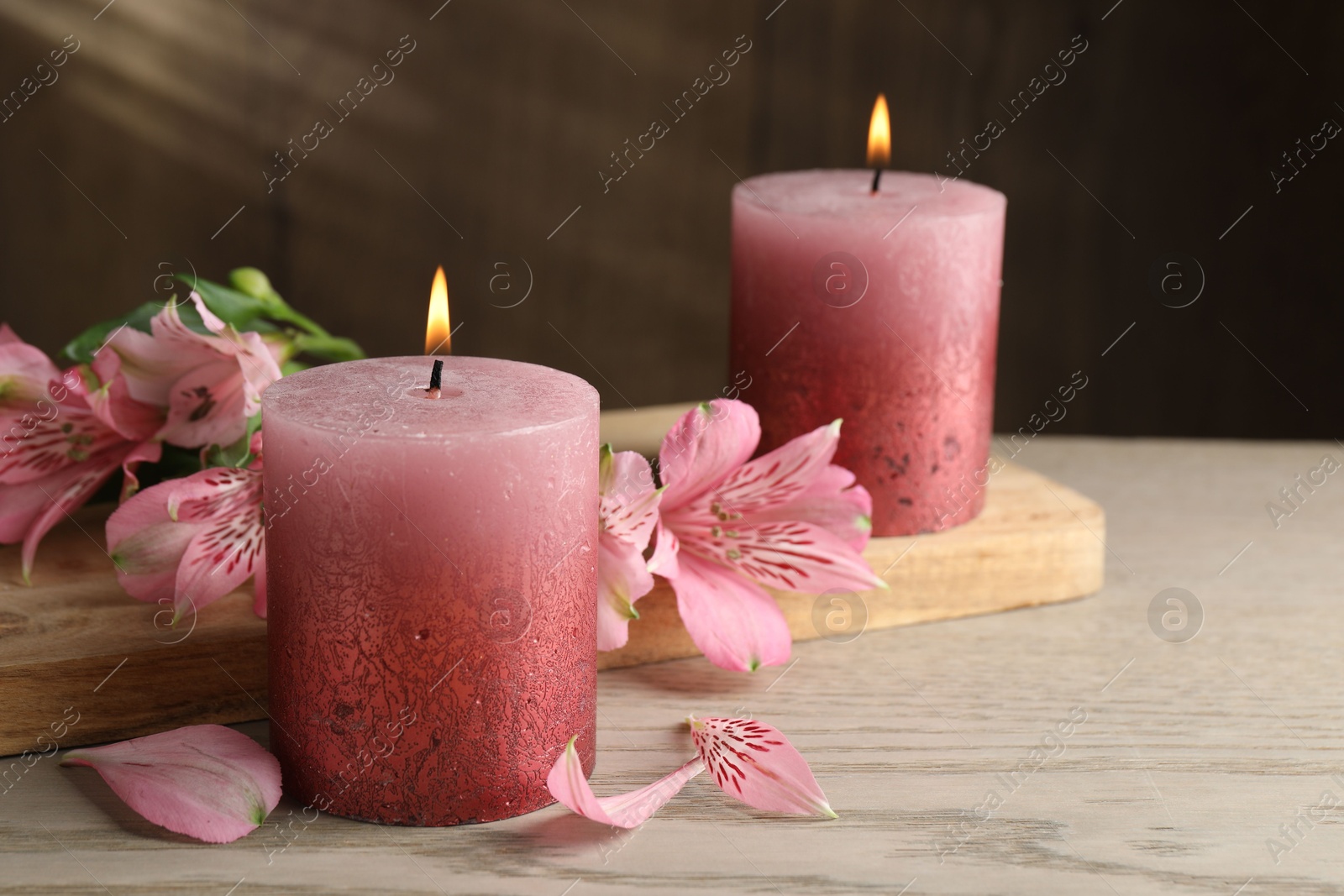 Burning candles and lily flowers on white wooden table, closeup Photo of Burning candles and lily flowers on white wooden table, closeup
