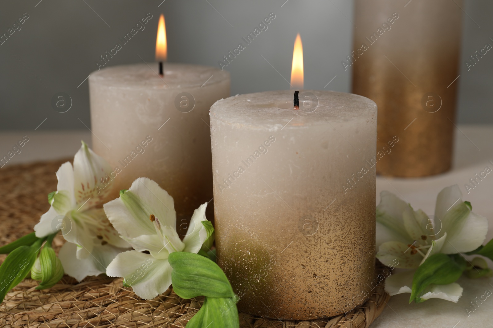 Burning candles and lily flowers on white table, closeup Photo of Burning candles and lily flowers on white table, closeup