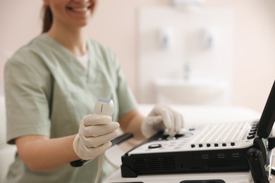 Photo of Professional sonographer with ultrasound machine in clinic, closeup