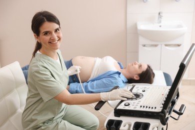 Photo of Sonographer conducting woman's prenatal ultrasound examination in clinic