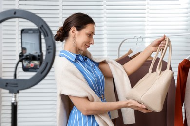 Photo of Professional stylist filming video on smartphone indoors