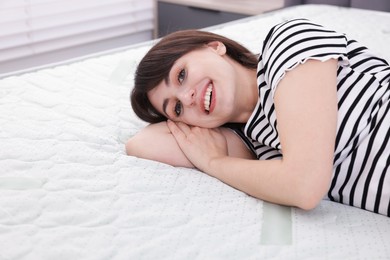 Photo of Beautiful woman lying on soft mattress at home