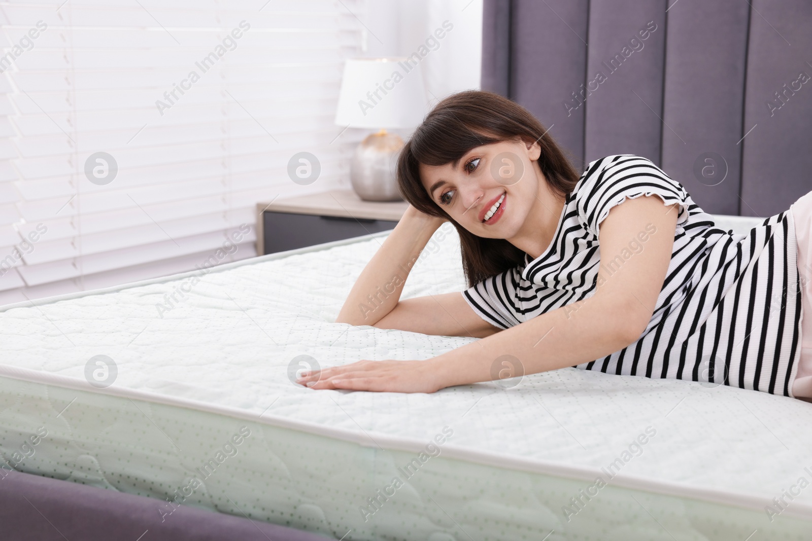 Beautiful woman lying on soft mattress at home Photo of Beautiful woman lying on soft mattress at home