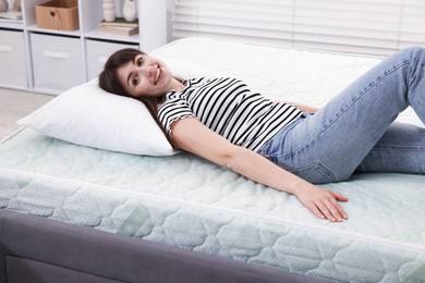 Photo of Beautiful woman lying on soft mattress at home