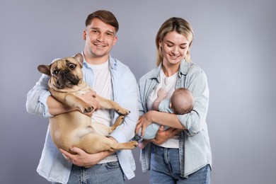 Photo of Happy family with little baby and cute dog on grey background