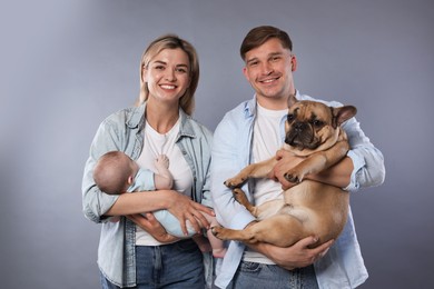 Photo of Happy family with little baby and cute dog on grey background
