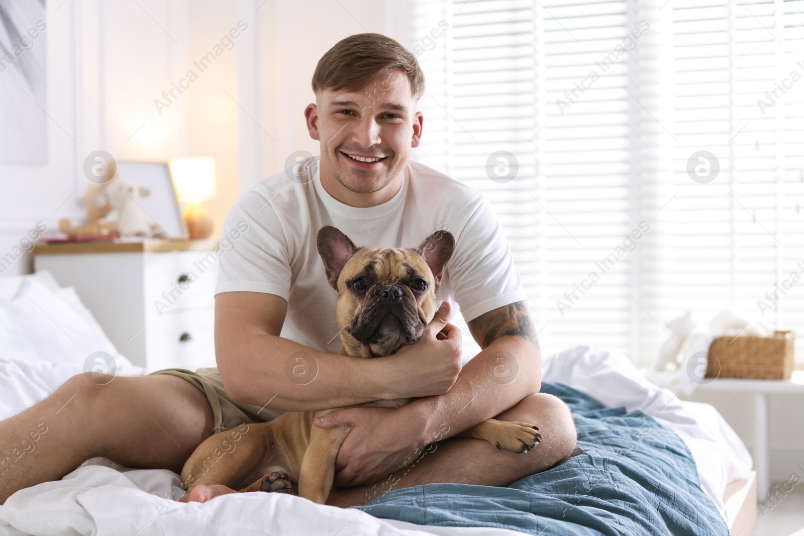 Photo of Man with his cute dog on bed at home