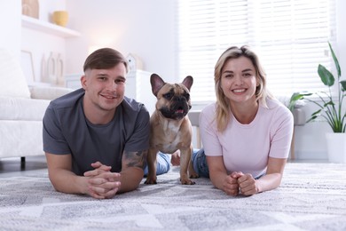Photo of Happy couple with cute dog at home
